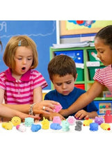 Kids playing with small squishy toys on a table, pastel colors