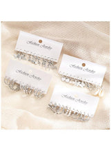 Silver hoop and charm earring sets on two cards, mixed hoops with small heart and star charms.