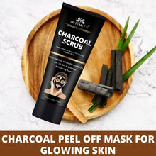 INTIMIFY charcoal scrub tube on wooden tray with charcoal bars and green stems