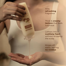 Hand holding cream Naturali shampoo bottle while foam spreads on palm