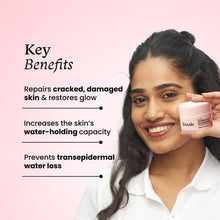 Skin repair cream jar held beside face by woman, pink jar for dry, sensitive skin