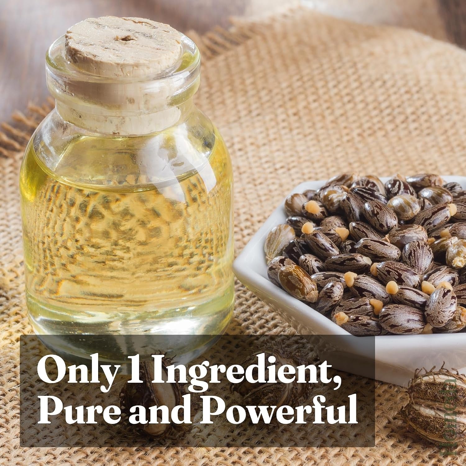 Cold-pressed castor oil bottle with castor seeds beside it.