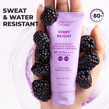 Berry Bright sunscreen tube in hands with blackberry fruit, sweat and water resistant