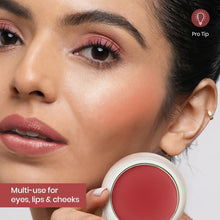 Raspberry red cream blusher on cheeks, with open blusher pot in view