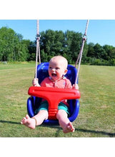 Blue and red baby swing with attached ropes, holding a smiling infant outdoors