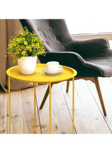Gold round side table with cup and saucer, plus potted flowers