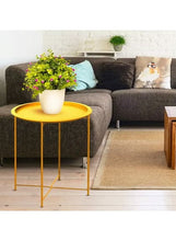 Gold round side table with potted flowers on circular tabletop