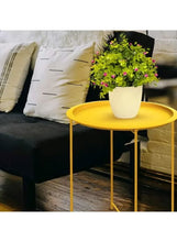 Gold round coffee side table with vase of flowers on top