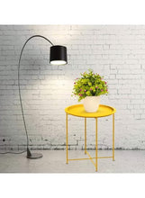 Gold round side table with four slender legs and circular top