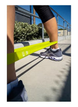 Bright yellow TPE resistance band used for leg exercise, flexible loop