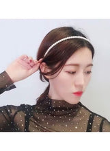 White pearl headband worn on dark hair with beaded center band