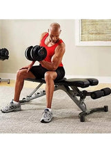 Adjustable dumbbell with stacked black plates and red accents on incline bench