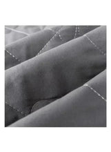 Dark grey quilted fabric close-up with stitched seam lines