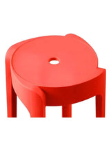 Red plastic stool seat close-up with center hole and rounded front edge