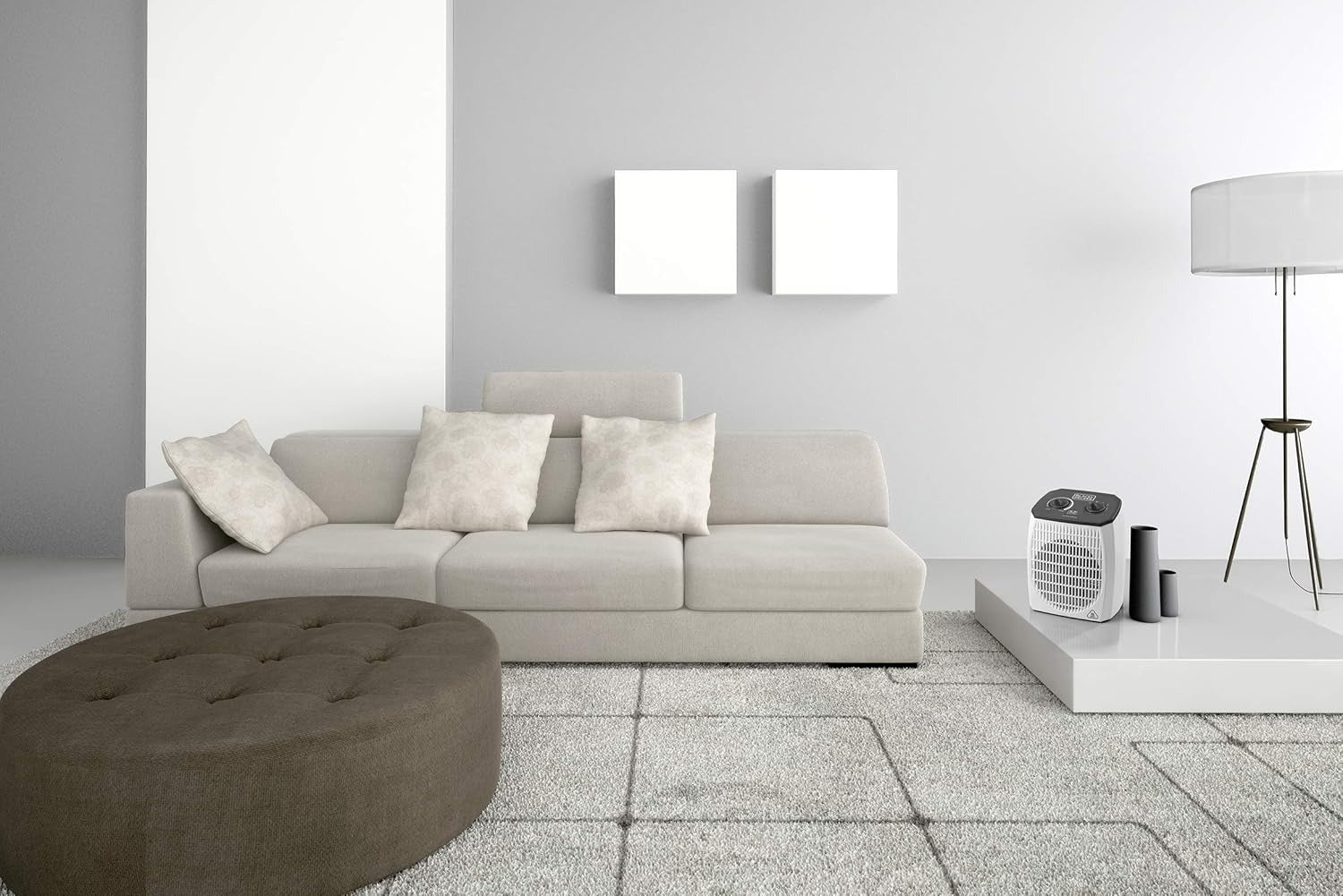 White compact vertical fan heater standing on the floor in a room