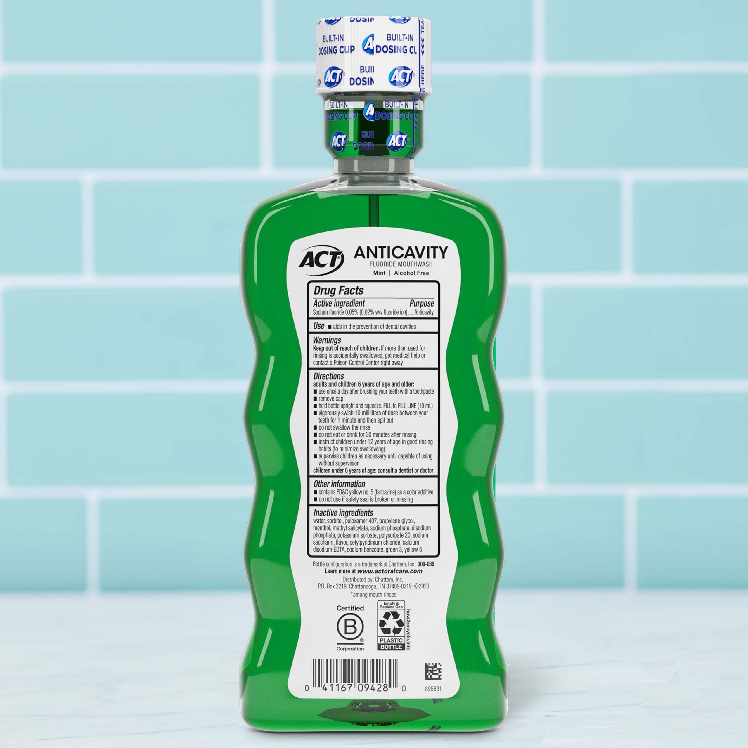 ACT Anticavity Fluoride Rinse green bottle back label showing drug facts and dosing cap on tiled bathroom counter