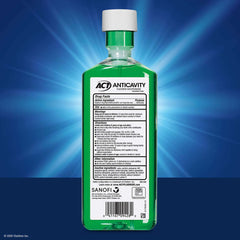 Back label of green bottle of ACT Anticavity Fluoride Rinse showing ingredients directions and barcode on blue backdrop