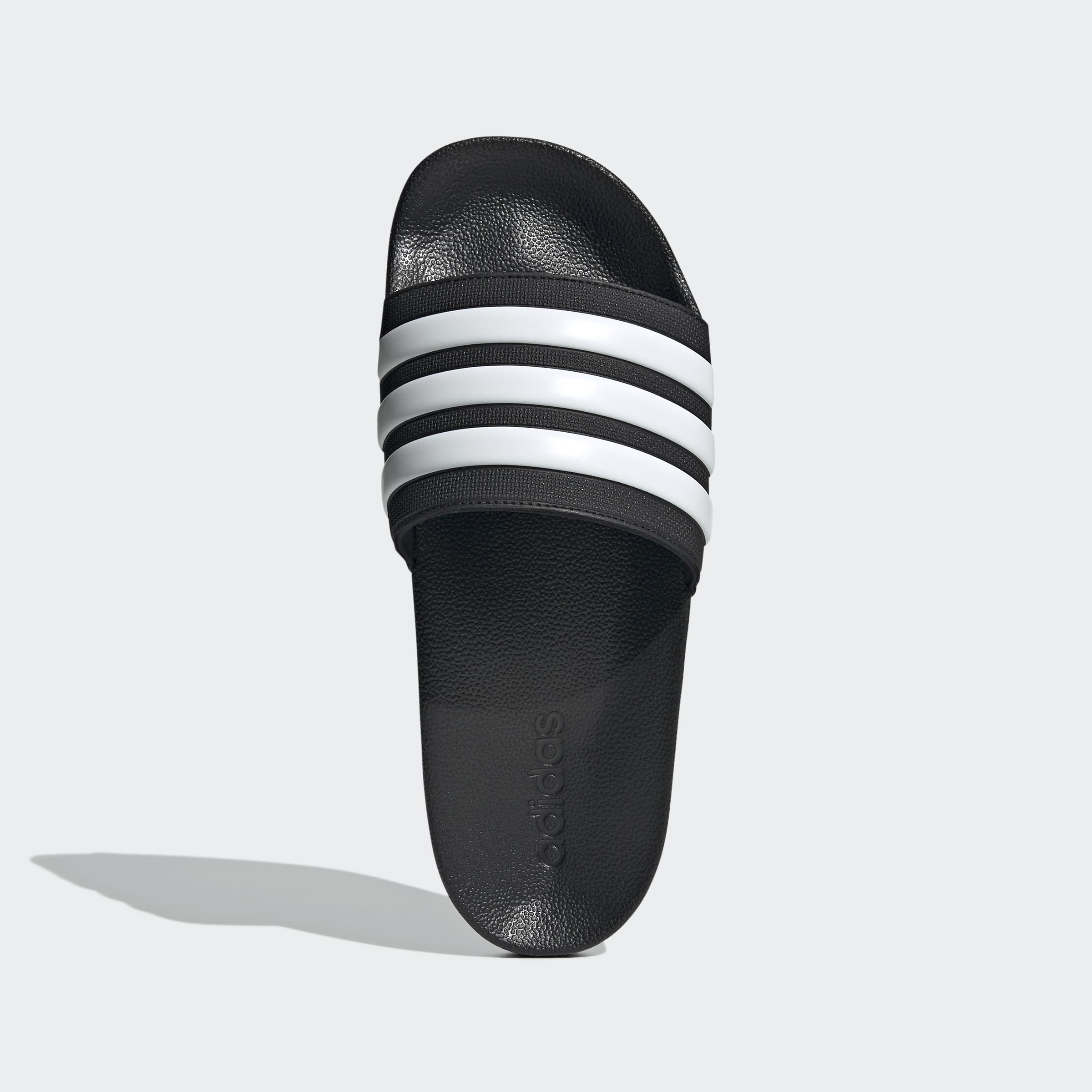 Black adidas pool slippers for men and women with white stripes and textured footbed
