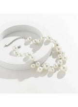 Pearl necklace on round display stand, round white pearls with silver-tone extender loop