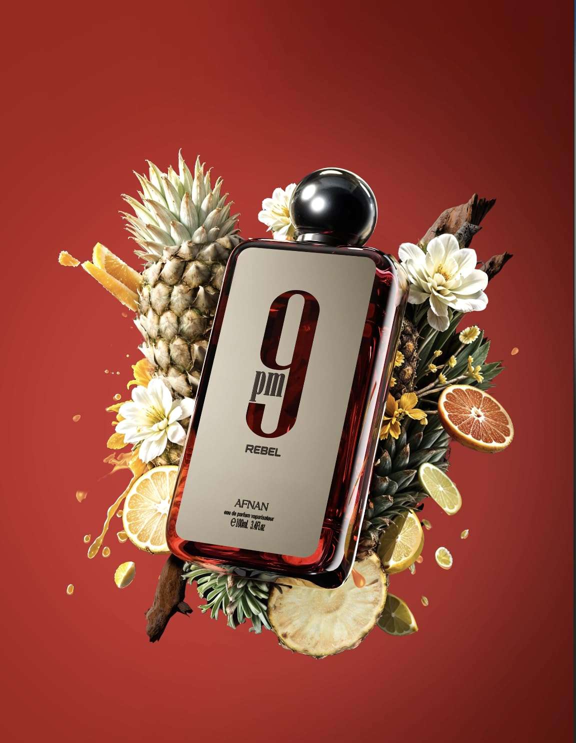 Afnan 9 PM Rebel perfume bottle with tropical fruits and white flowers on red background