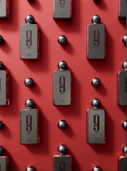Multiple bottles of Afnan 9 PM Rebel perfume arranged on a red background with black caps