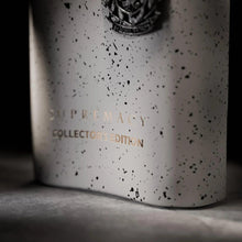 Lower perfume bottle with speckled light-gray texture and embossed text