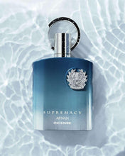 Unisex eau de parfum bottle, dark blue/teal with silver cap ring and crest logo.
