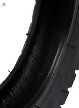 Black scooter tire tread and grooves, close-up side view