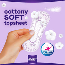 Cottony soft topsheet pantyliner held in hand, white with purple printed pattern