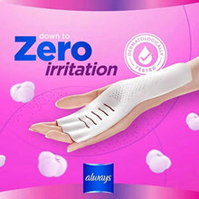 Winged sanitary pad on backing, held in hands