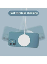 White circular wireless charging pad magnetically attached to a phone
