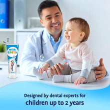 Baby milk teeth toothpaste tube, 0–2 years, 50 ml shown beside child