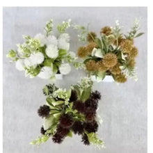 Artificial flower bouquets in white pots with light green, white, brown, and dark blooms