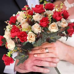 Huitich artificial mini rose bouquet with red and cream roses held by a couple in wedding attire