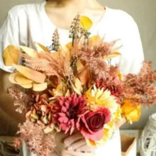 Artificial flower bouquet with pink and orange roses with leafy filler held in hand