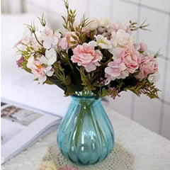 Huitich artificial mini rose flowers in pink and white arranged in a blue glass vase on a table