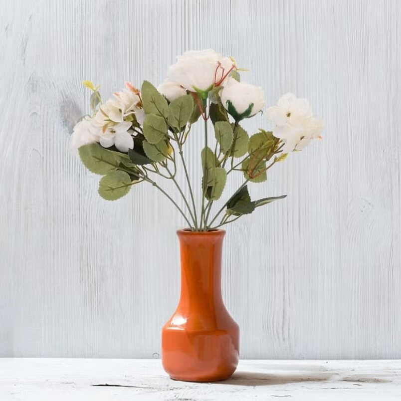 Huitich artificial mini white roses arranged in an orange vase on a white wooden surface