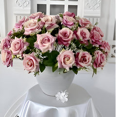 Huitich artificial pink flowers for home decor arranged in a white vase on a draped table