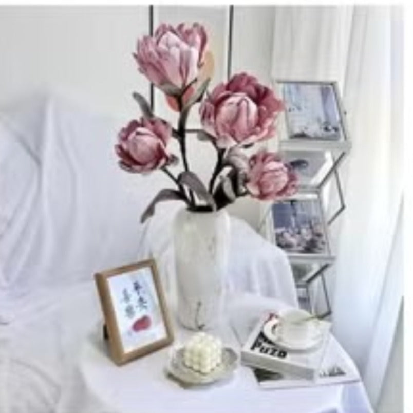 Huitich artificial pinkish purple flowers in white vase on table with framed art and decor
