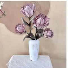 Huitich artificial pinkish purple flowers arranged in a white marble vase on a white cloth
