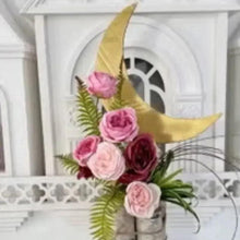 Artificial rose bouquet in vase, pink and burgundy blooms with green fern and yellow leaf