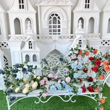 Artificial rose wall garland with multicolor blooms and green leaves along white arch decor
