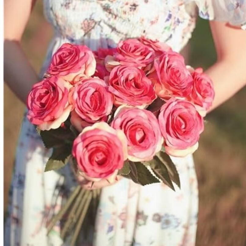 Huitich artificial roses bouquet with vibrant pink petals held by person in floral dress