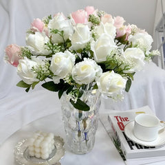 Huitich artificial white flower arrangement with pink accents in a clear textured vase on a white table