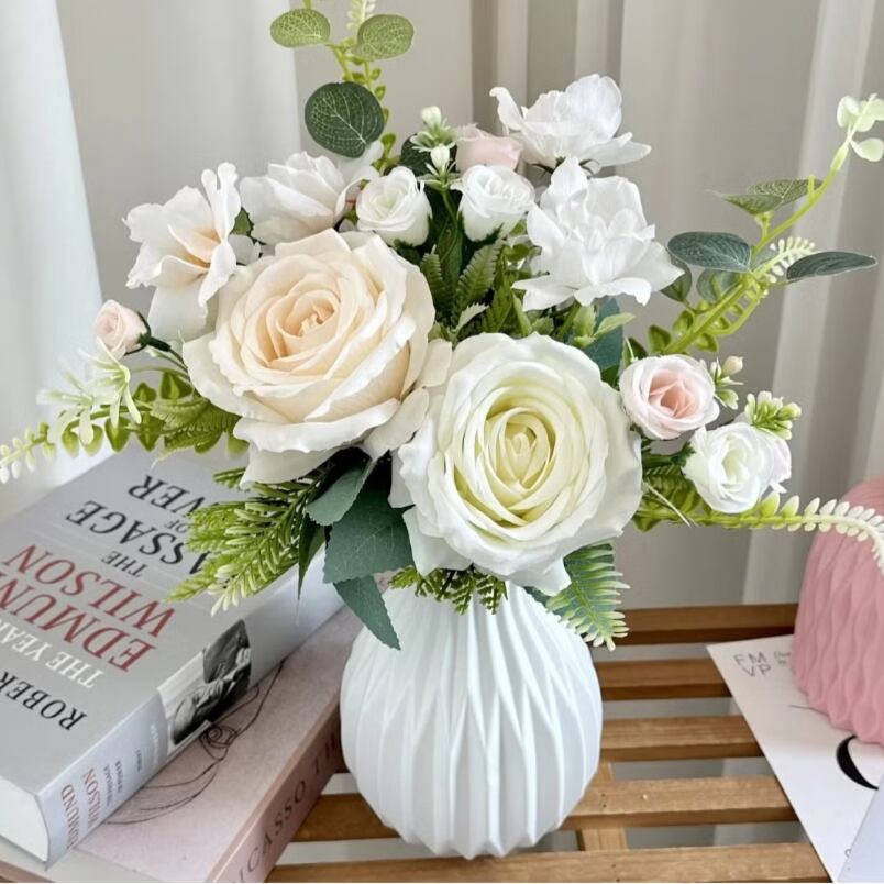 Huitich artificial white flower decor in a white textured vase on a wooden table with books