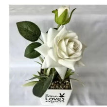 Artificial white rose potted plant in white square planter with green leaves