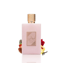 Perfume bottle with rose-pink front and gold cap, with flowers beside it