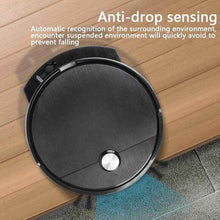 Robotic vacuum cleaner with anti-drop sensing, black round body near a floor edge