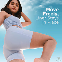 Woman in light blue active shorts and crop top stretching against sky promoting organic cotton panty liners that stay in place