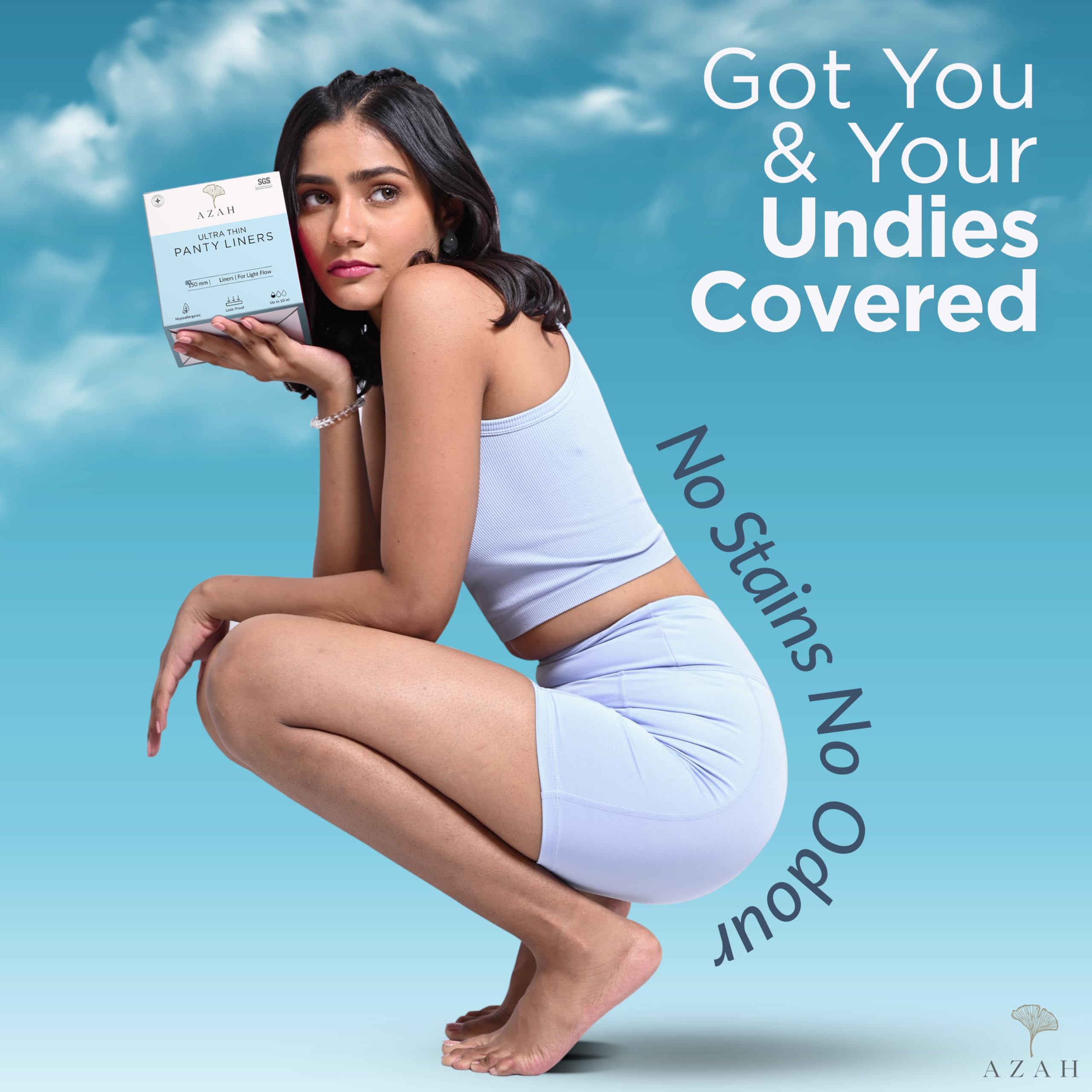 AZAH model in light blue activewear holding box of organic cotton panty liners on blue background
